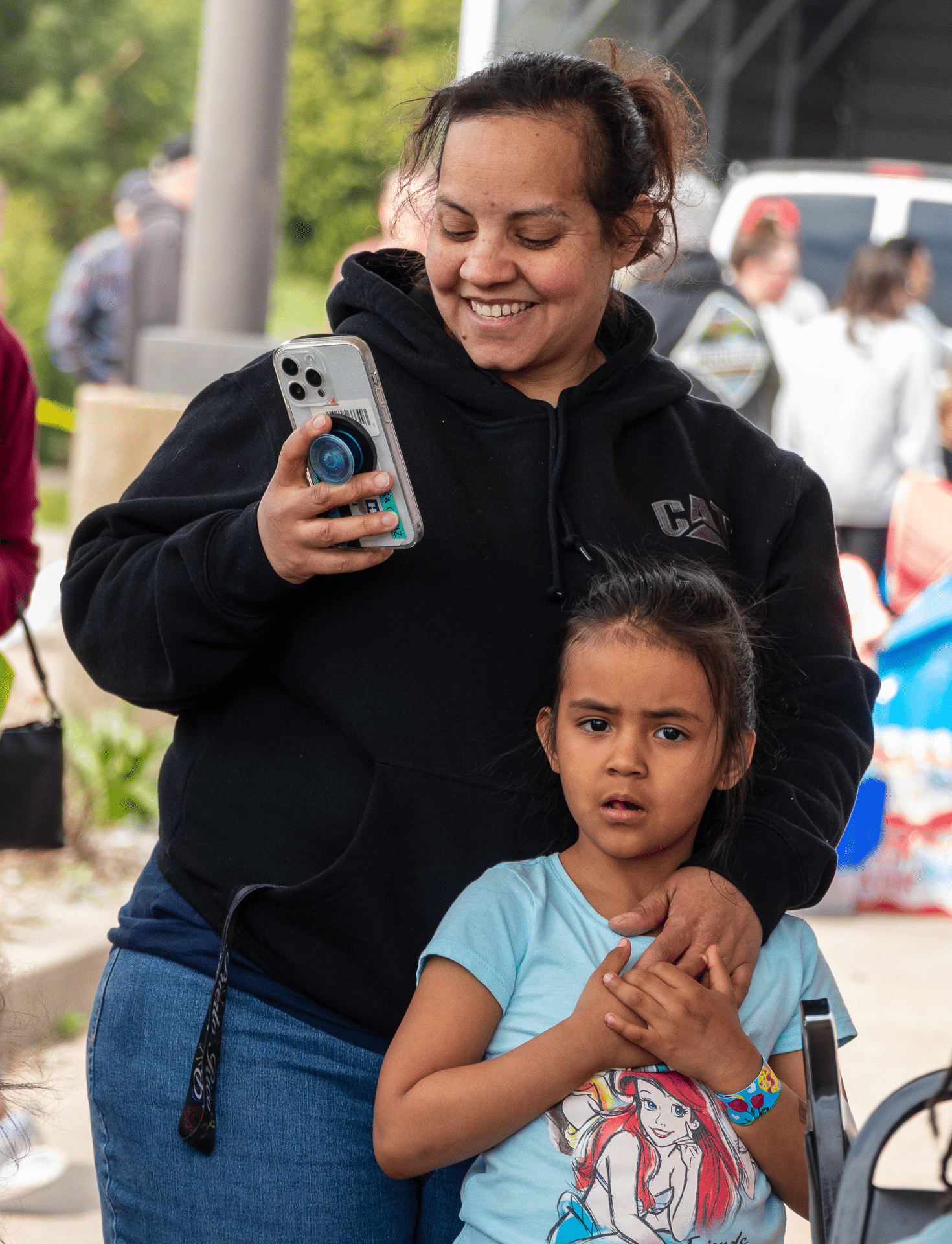 A welcoming group gathers as a woman smiles and a girl stands nearby—sharing hope and community together. - Muscatine Church of Christ