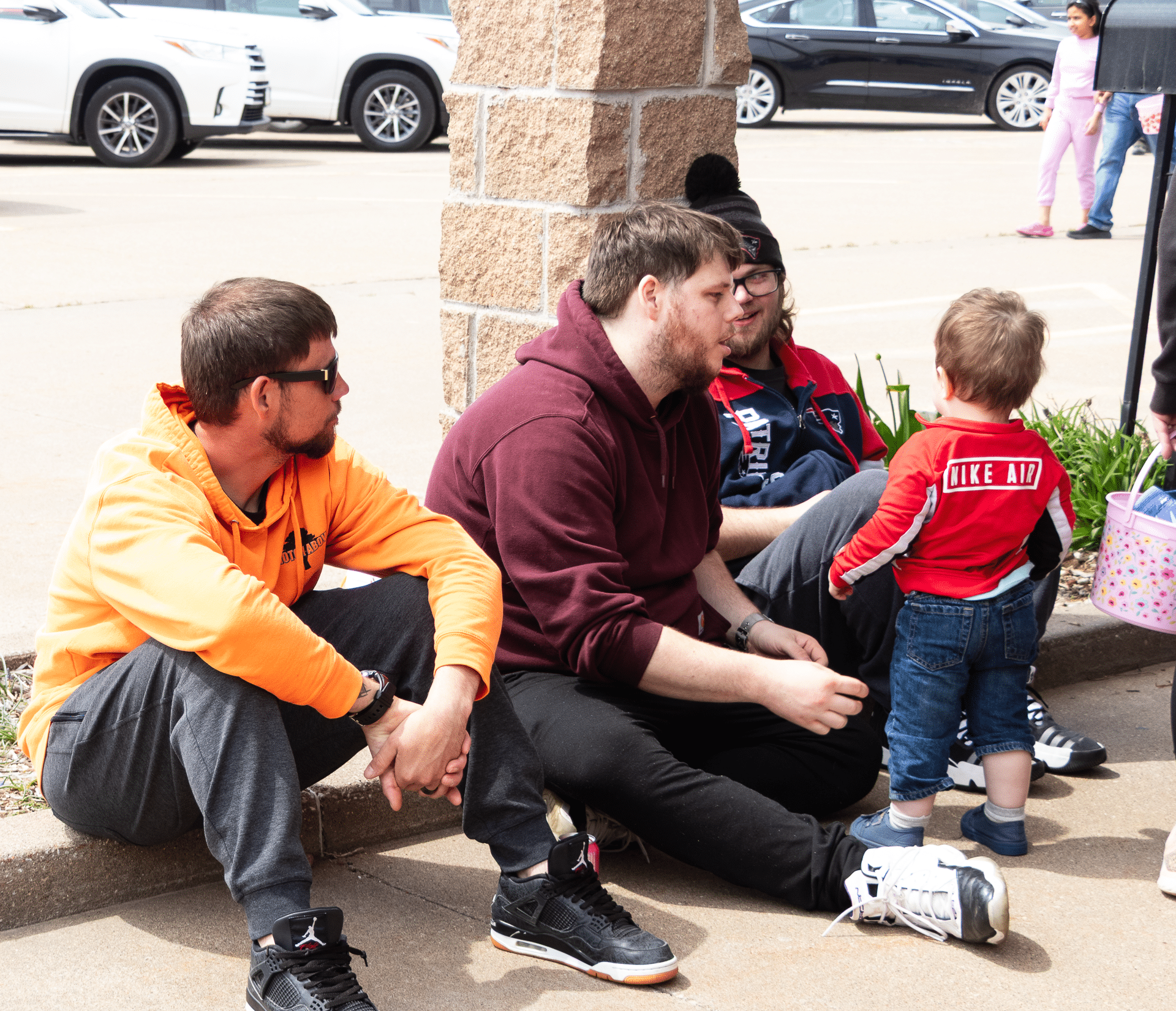 Three friends and a child share conversation outside, surrounded by the warmth of community and hope. - Muscatine Church of Christ