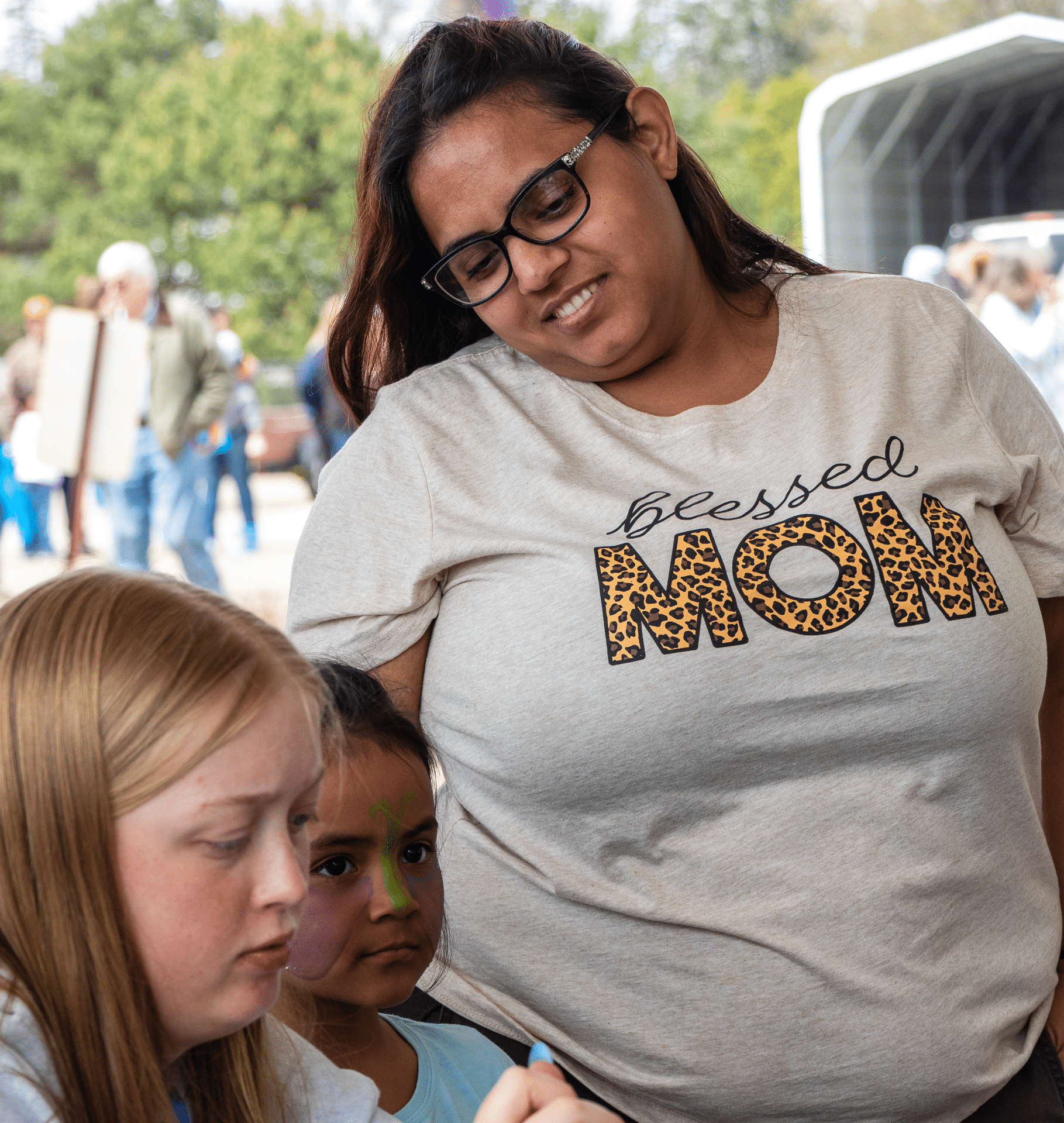 A smiling mom and kids enjoy our outdoor event—everyone is welcome to join in the fun, hope, and community. - Muscatine Church of Christ