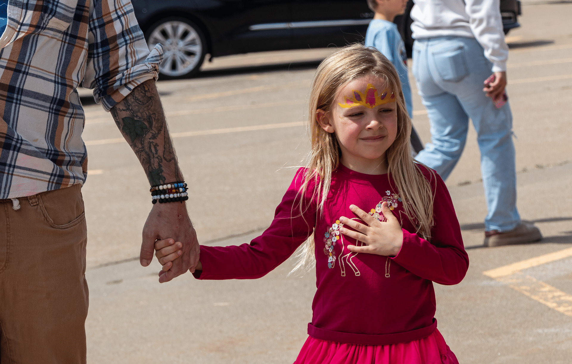 A joyful young girl in a pink dress holds a welcoming hand, ready to join our caring church family. - Muscatine Church of Christ