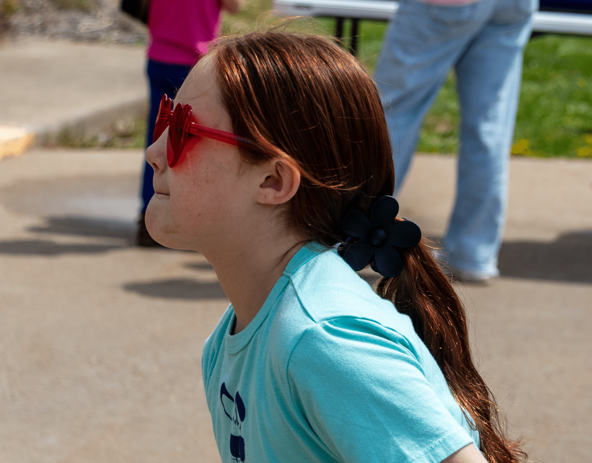 A smiling girl in heart-shaped glasses enjoys the outdoors, reminding us of joy and hope found in community. - Muscatine Church of Christ