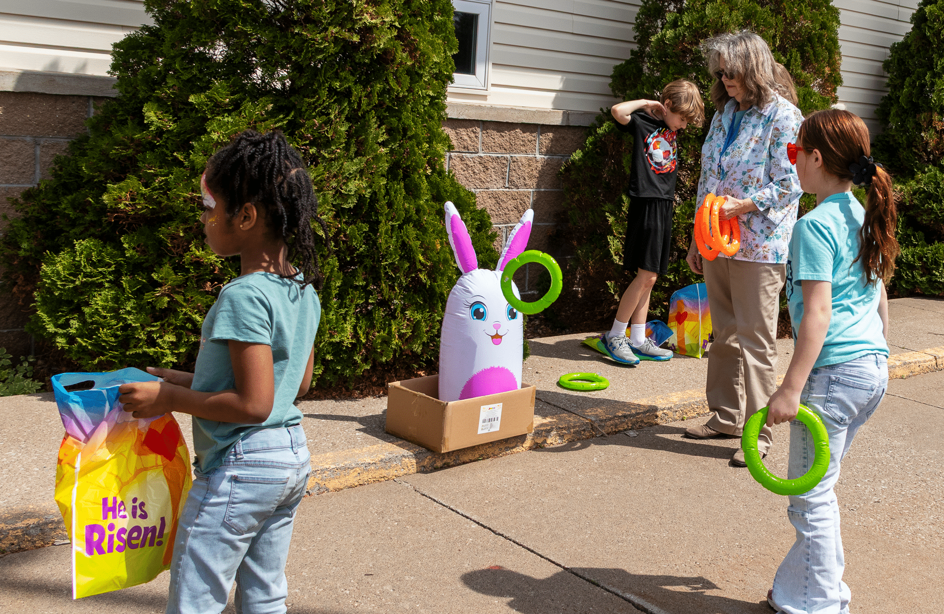 Children joyfully play ring toss together outside, sharing laughter and hope at our welcoming church event. - Muscatine Church of Christ
