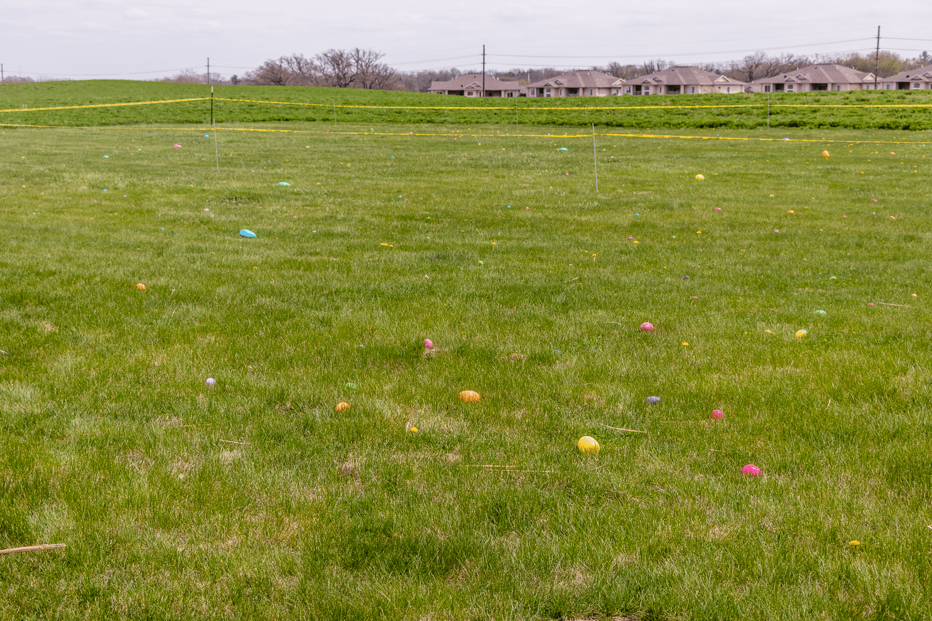 A bright field with colorful Easter eggs, welcoming our community to celebrate hope and joy together. - Muscatine Church of Christ