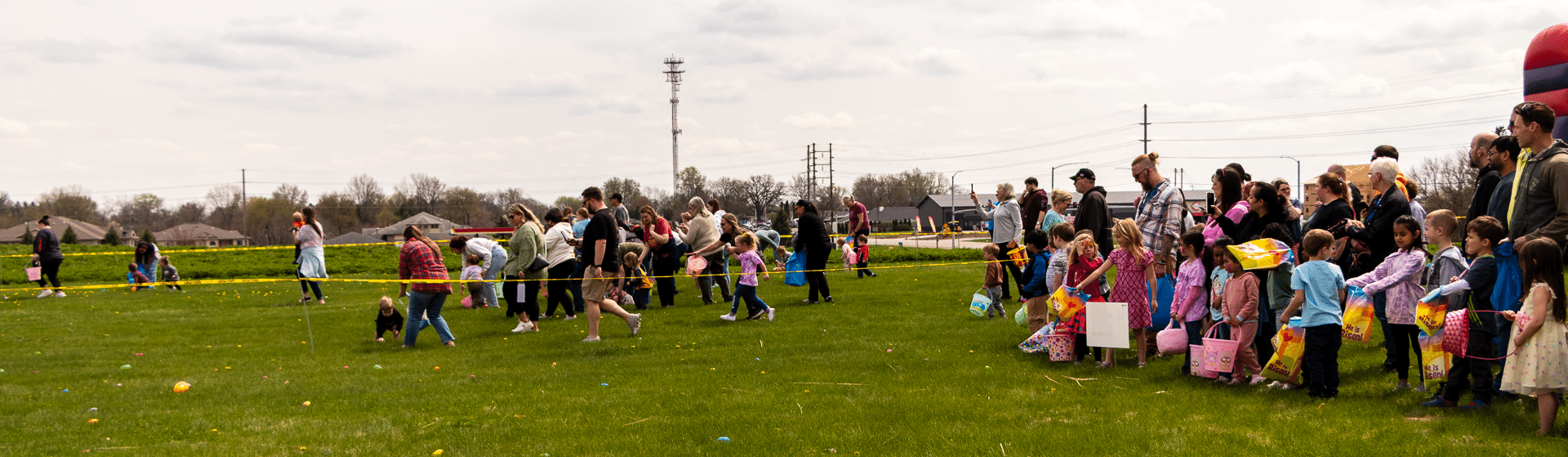 Families and children join together on a grassy field for a joyful egg hunt, sharing smiles and hope under the clouds. - Muscatine Church of Christ