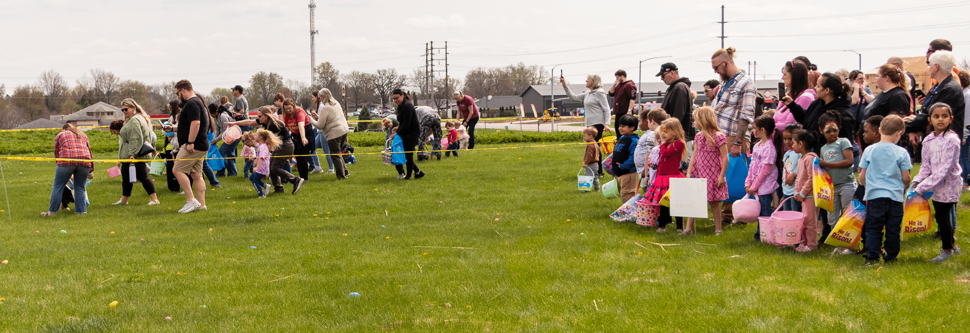 Children with baskets wait, excited for the egg hunt, as our church family enjoys a joyful day together on the lawn. - Muscatine Church of Christ