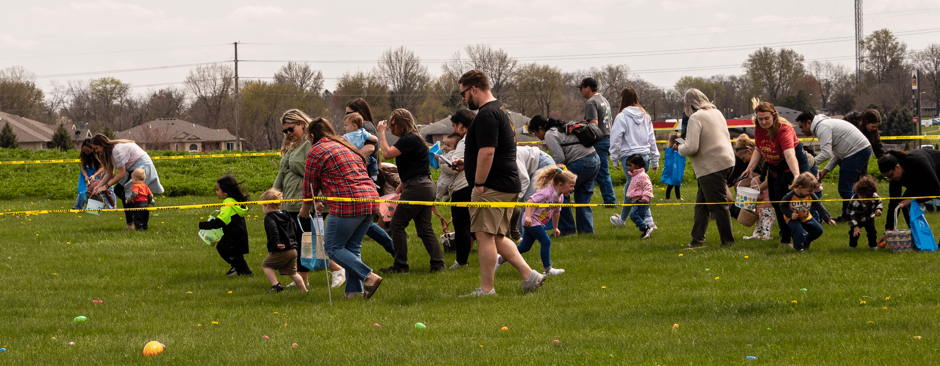 Families and children joyfully gather for an outdoor Easter egg hunt, sharing hope and community on a sunny day. - Muscatine Church of Christ