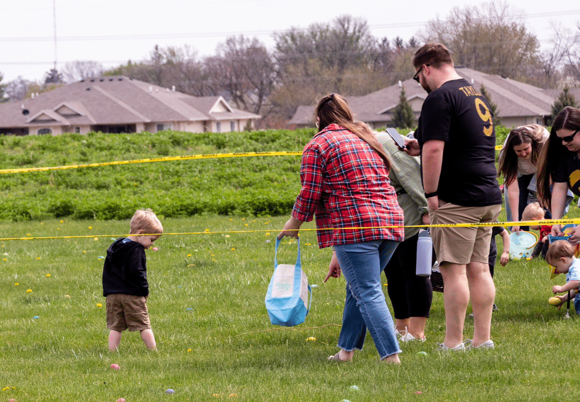Children and adults joyfully gather for an egg hunt, sharing smiles, hope, and community on a sunny grassy field. - Muscatine Church of Christ