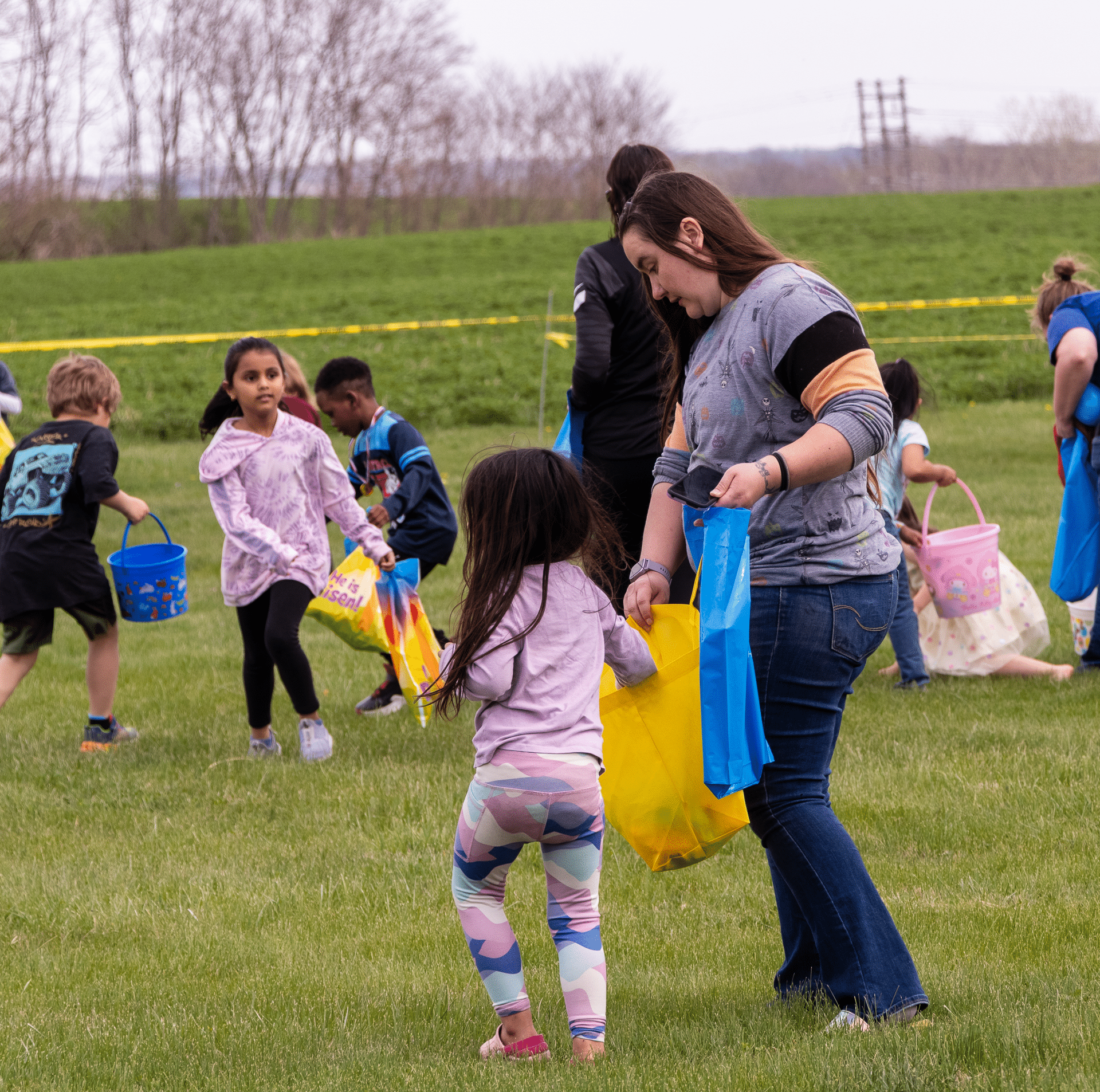 Children and adults smile together on a sunny lawn, ready for our joyful church egg hunt—everyone is welcome!. - Muscatine Church of Christ