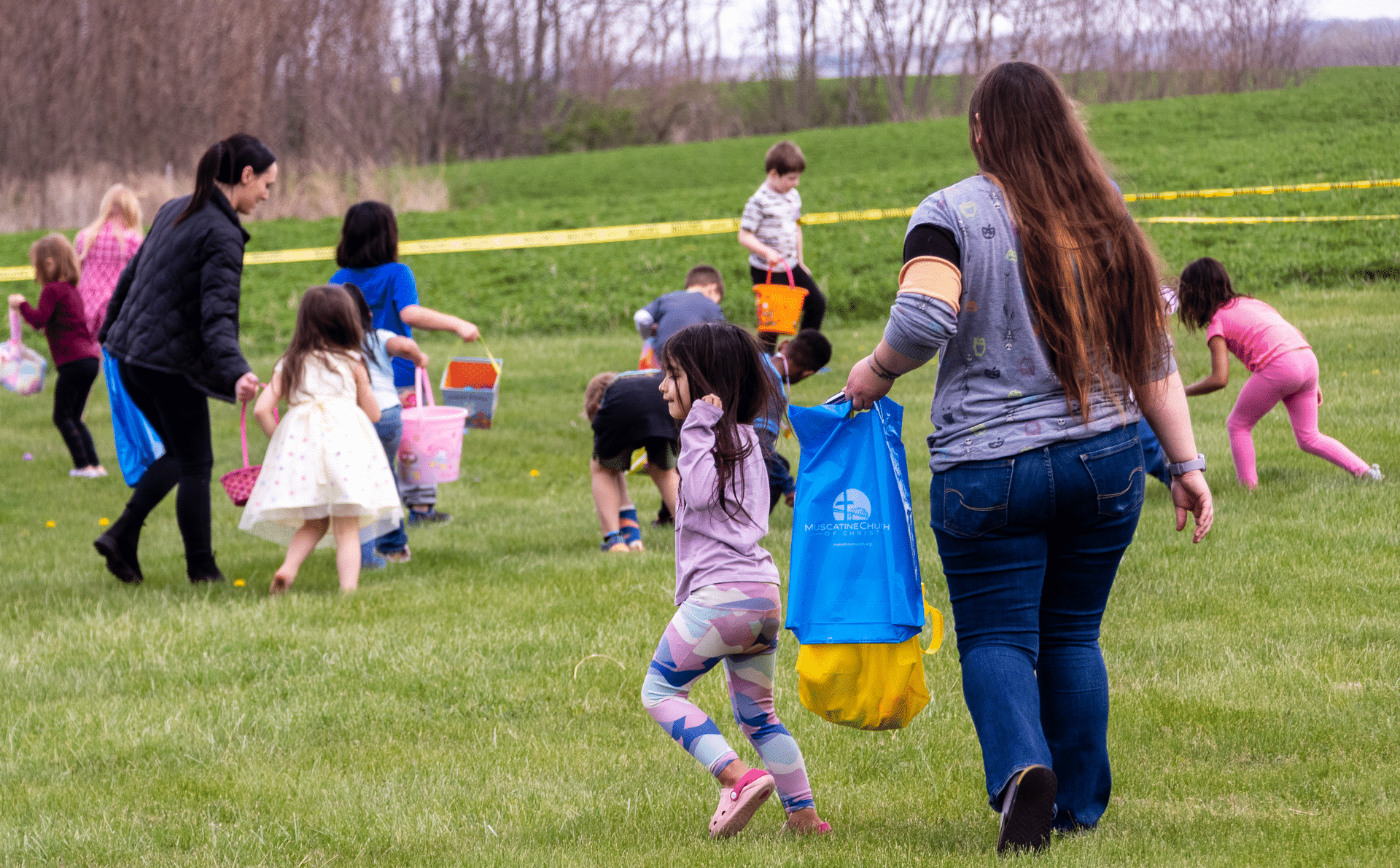Families and friends joyfully gather for an outdoor egg hunt, sharing smiles and hope on a bright, welcoming day. - Muscatine Church of Christ