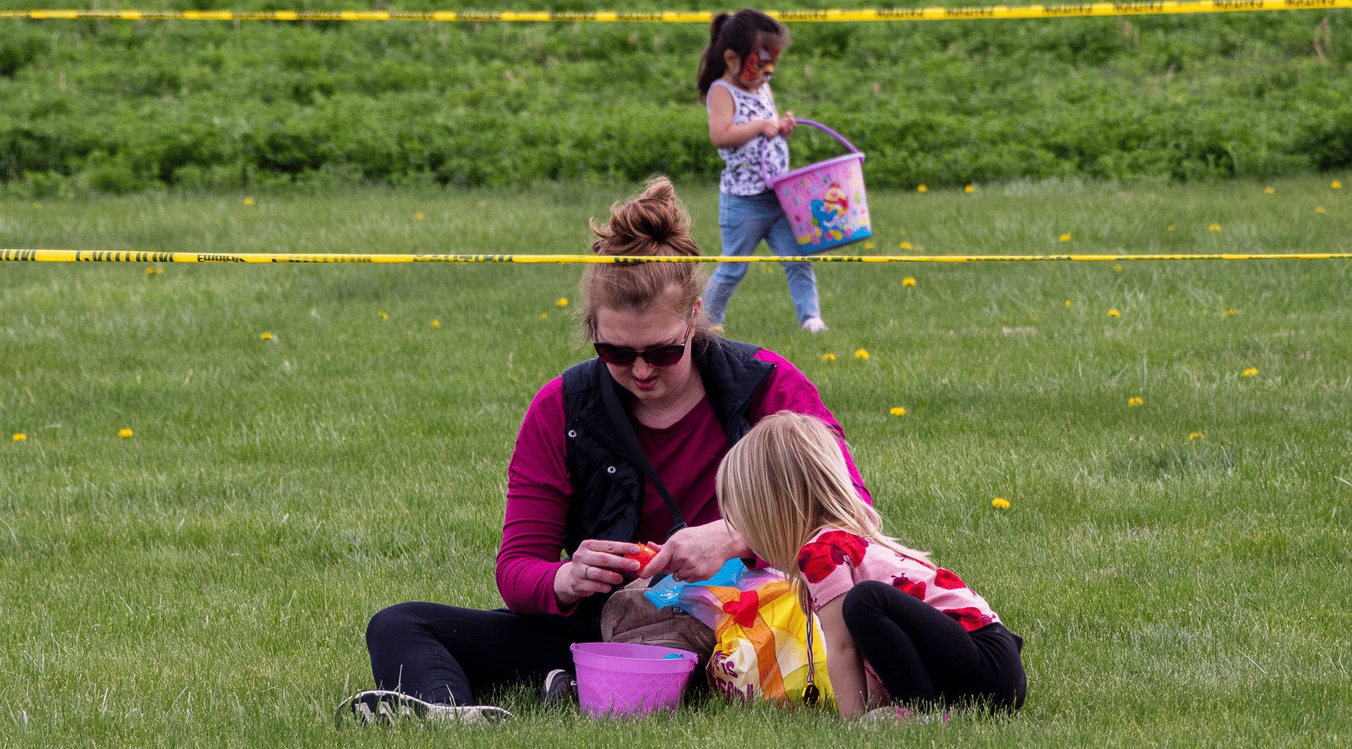 Welcoming families gather on the lawn, sharing laughter and hope as children enjoy an Easter egg hunt together. - Muscatine Church of Christ