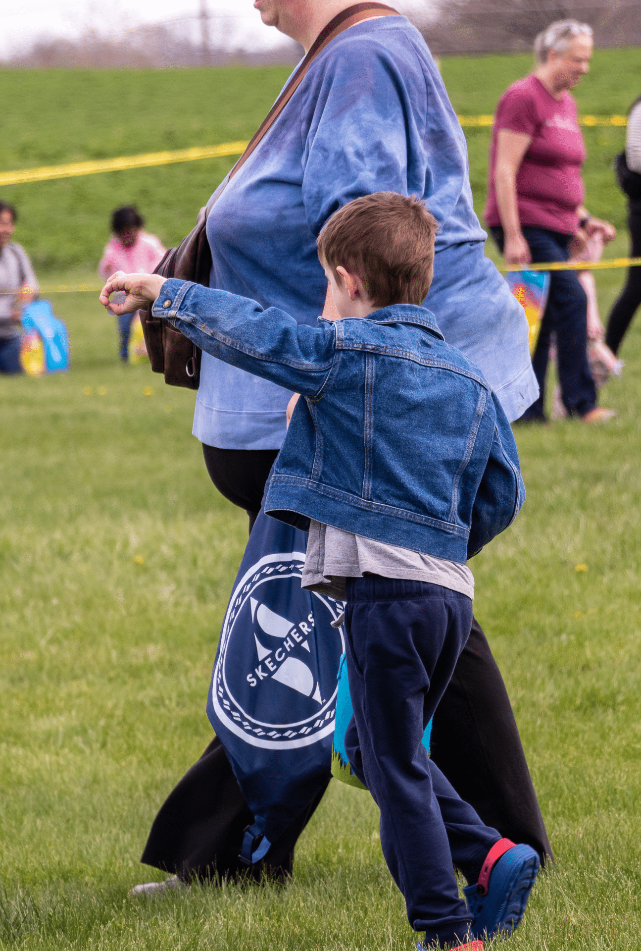A young boy walks with an adult at a church event, surrounded by caring community and joyful fellowship. - Muscatine Church of Christ