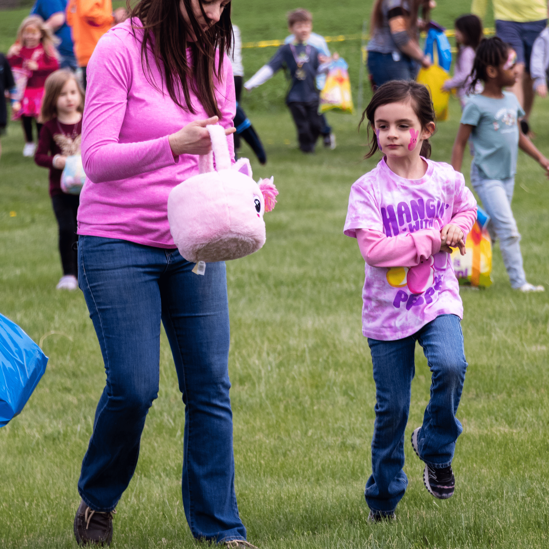 A woman and young girl join others outdoors, sharing smiles and hope at a joyful Muscatine community gathering. - Muscatine Church of Christ