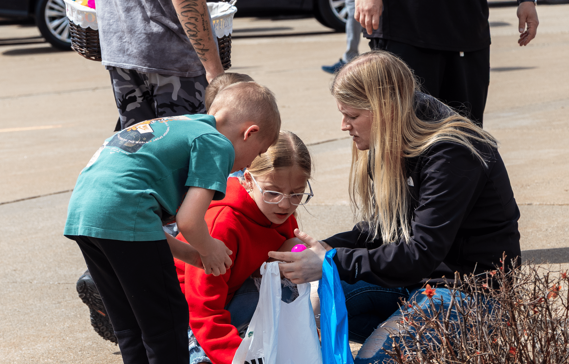 A caring woman and two kids share a joyful moment outdoors, surrounded by our welcoming church community. - Muscatine Church of Christ