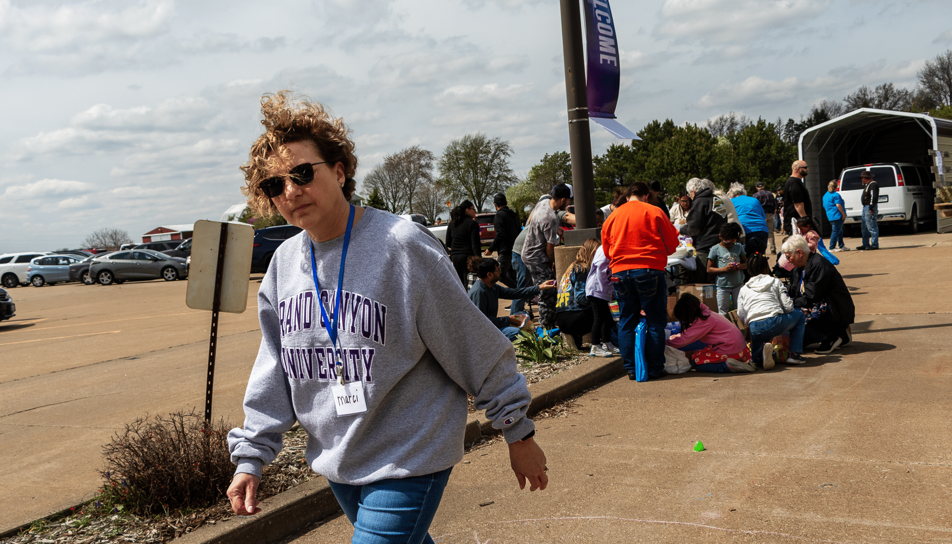 A welcoming group gathers by a tent as a smiling woman arrives, ready to share hope and community together. - Muscatine Church of Christ