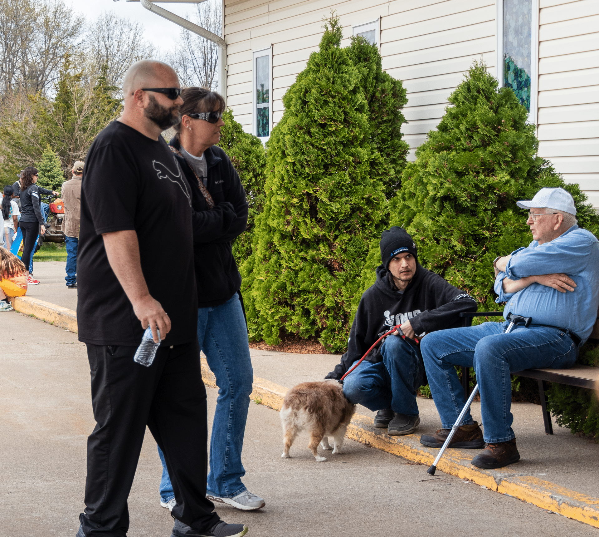 Neighbors share conversation and smiles outside our church, inviting all to connect and find hope together. - Muscatine Church of Christ