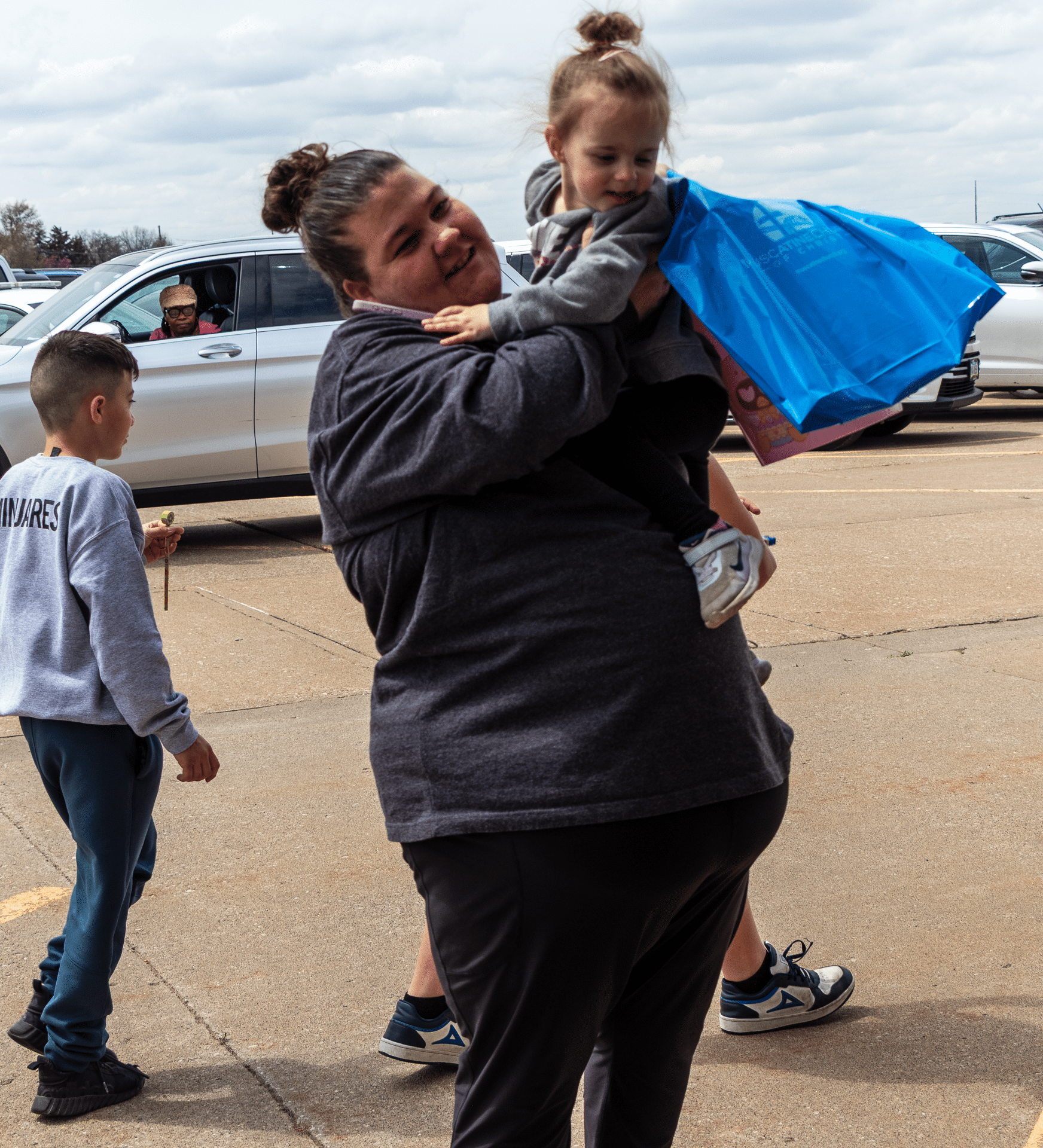 A caring woman welcomes children in our lot—together, we share hope and community at Muscatine Church of Christ. - Muscatine Church of Christ