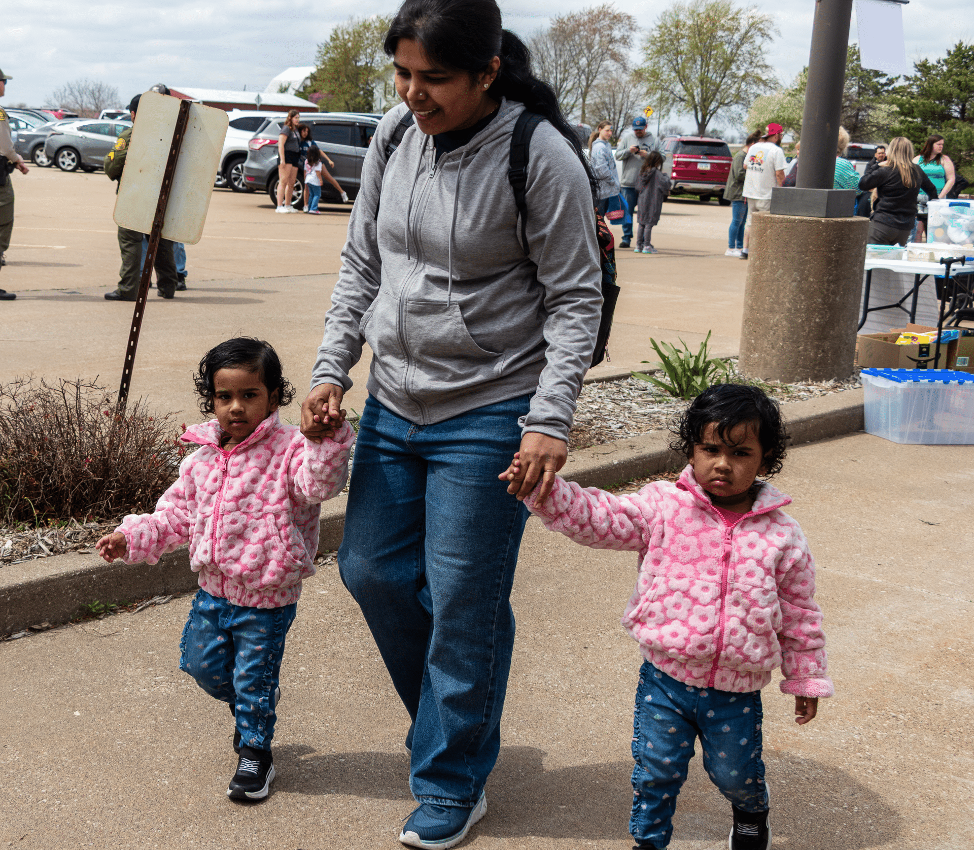 A caring adult walking hand in hand with two children, showing our church’s warmth, welcome, and hope for all. - Muscatine Church of Christ