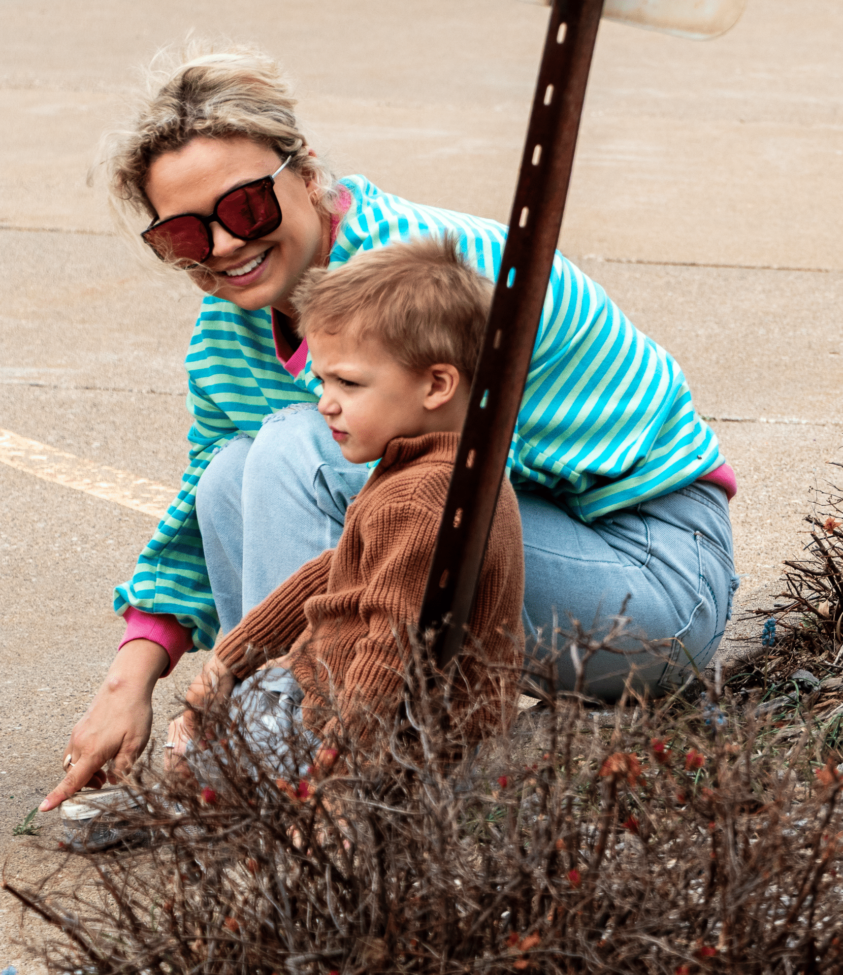 An adult and child share a joyful moment outside, welcoming all with smiles and hope in our loving community. - Muscatine Church of Christ
